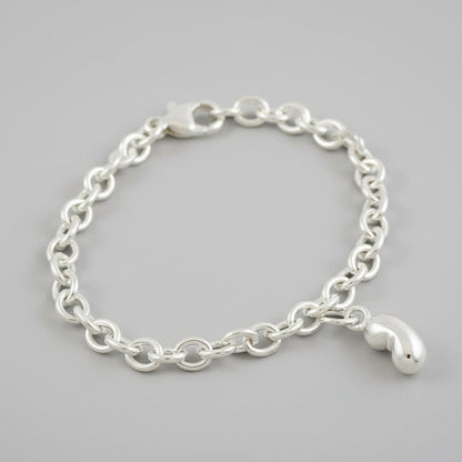 Silver baby bean charm with delicate detailing, displayed on a white background by Scarlett Jewellery.