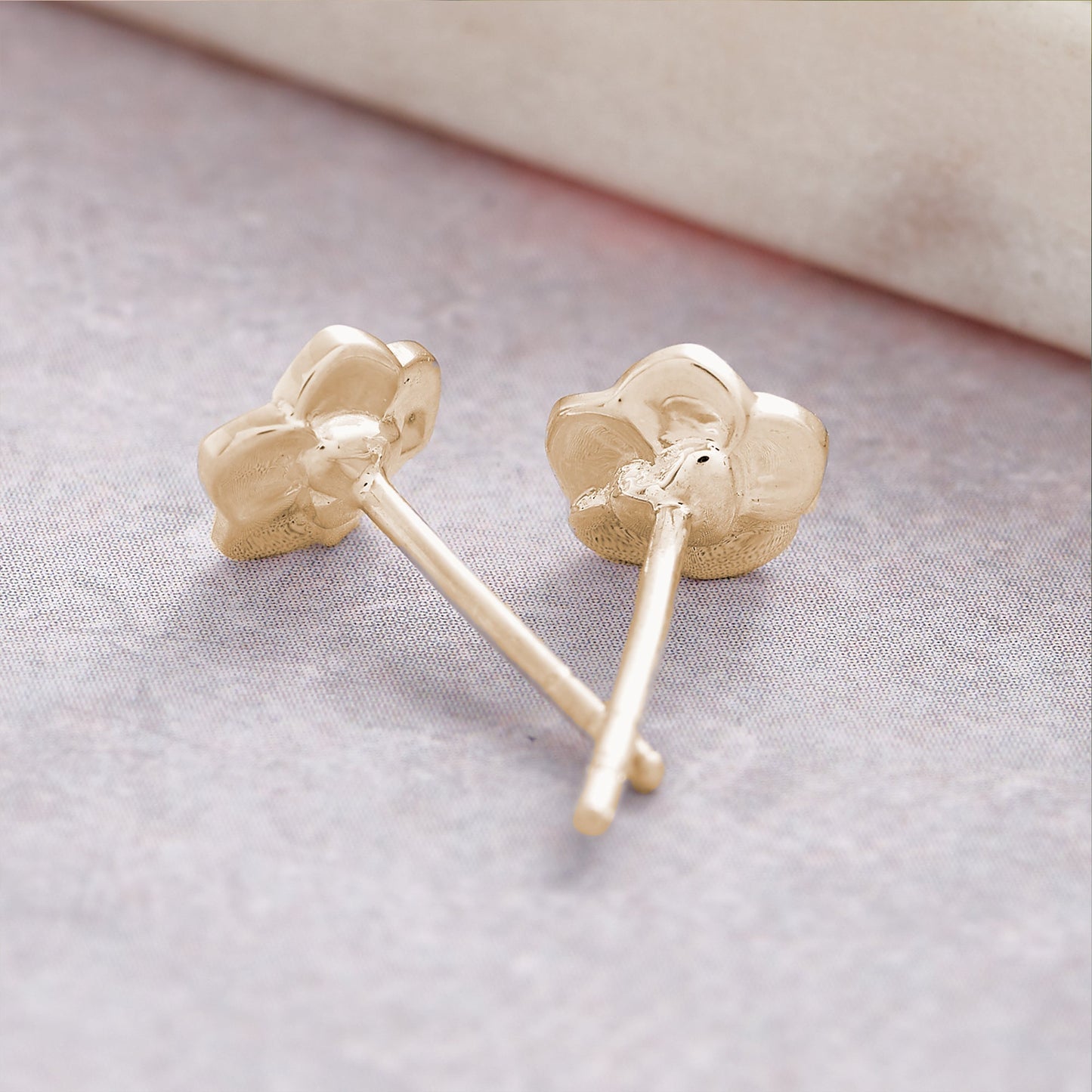 Tiny gold vermeil stud earrings with a delicate forget-me-not design by Scarlett Jewellery.