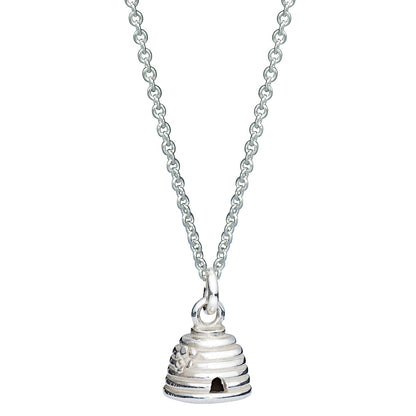 A silver beehive charm with intricate detailing, displayed on a soft pink background, by Scarlett Jewellery.