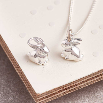 A silver bunny rabbit charm with detailed texture, displayed on a soft white background by Scarlett Jewellery.
