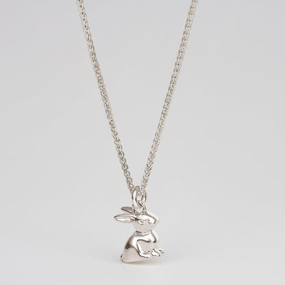 A silver bunny rabbit charm with detailed texture, shown against a soft background, by Scarlett Jewellery.