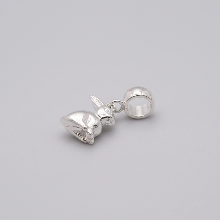 A silver bunny rabbit charm with detailed texture, displayed on a soft white background by Scarlett Jewellery.