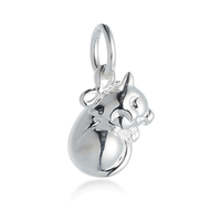 A silver cat charm with intricate detailing, displayed on a soft fabric background, by Scarlett Jewellery.
