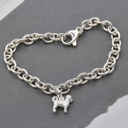 A silver cavapoo dog charm shaped like a small dog, detailed with a smooth finish and delicate features, by Scarlett Jeweller