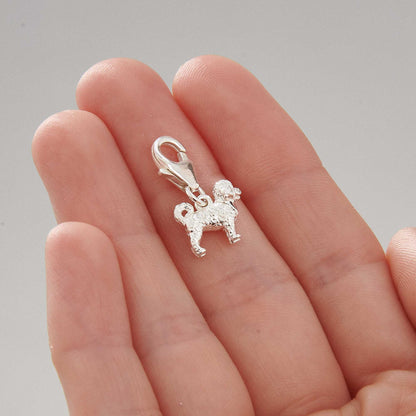 A silver cavapoo dog charm shaped like a small dog, detailed with realistic features, by Scarlett Jewellery.