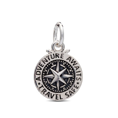 A silver travel safe compass charm with personalized engraving, displayed on a soft background by Scarlett Jewellery.