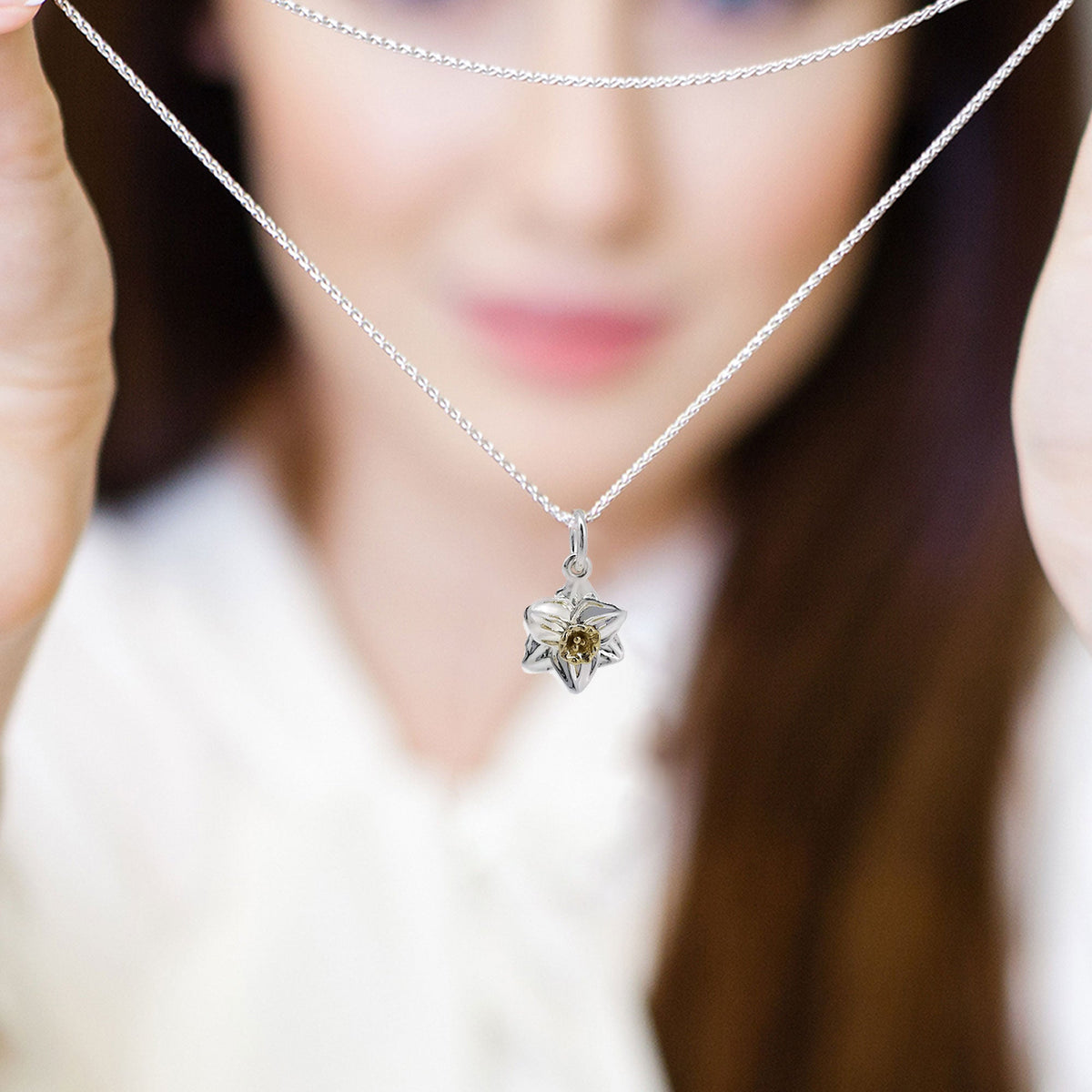 A daffodil flower charm in silver and solid gold, detailed with intricate petal textures, by Scarlett Jewellery.