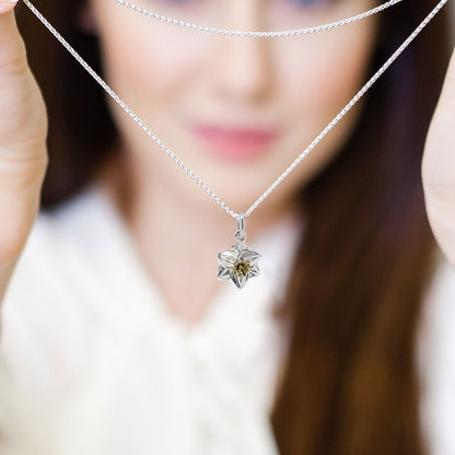 A daffodil flower charm in silver and solid gold, detailed with intricate petal textures, by Scarlett Jewellery.
