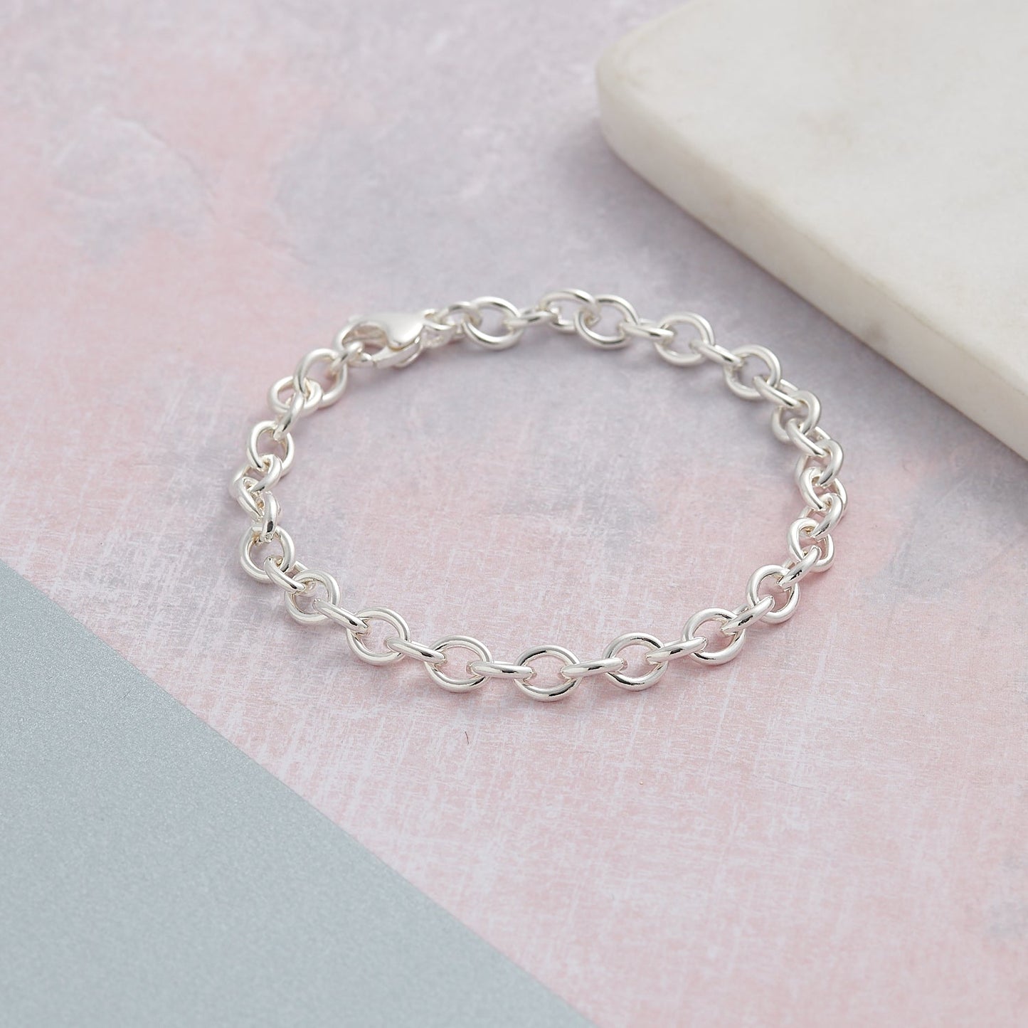 A silver mini lifetime charm bracelet with a delicate chain and personalized charms by Scarlett Jewellery.