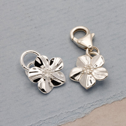 Silver forget-me-not flower charm with personalized engraving, styled on a necklace chain by Scarlett Jewellery.