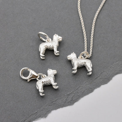A silver fox terrier dog charm shaped like a paw print, displayed on a soft white background by Scarlett Jewellery.