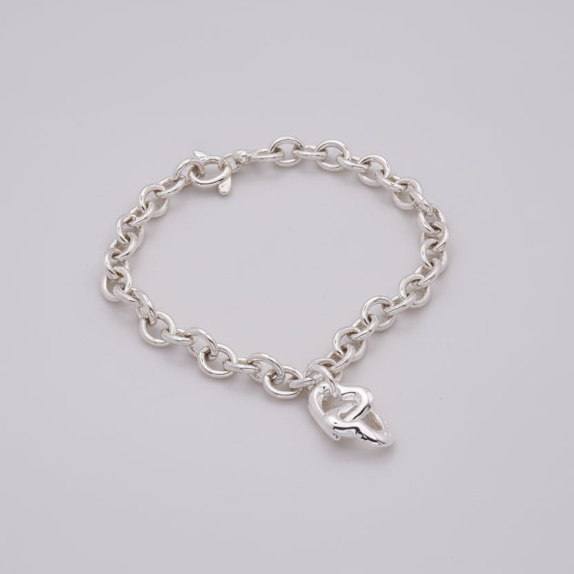 A silver friendship charm with engraved text on a chain, displayed against a soft background by Scarlett Jewellery.