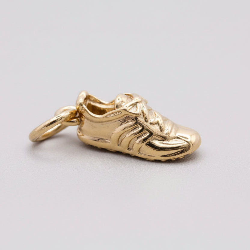 Silver charm with detailed gemstone accents worn on a running shoe by Scarlett Jewellery.