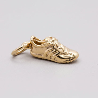 Silver charm with detailed gemstone accents worn on a running shoe by Scarlett Jewellery.