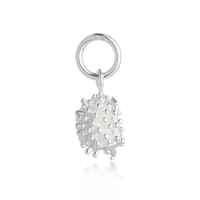 A silver hedgehog charm with detailed texture, displayed on a soft blue background by Scarlett Jewellery.