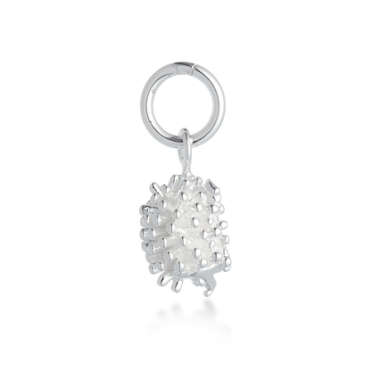 A silver hedgehog charm with detailed texture, displayed on a soft blue background by Scarlett Jewellery.