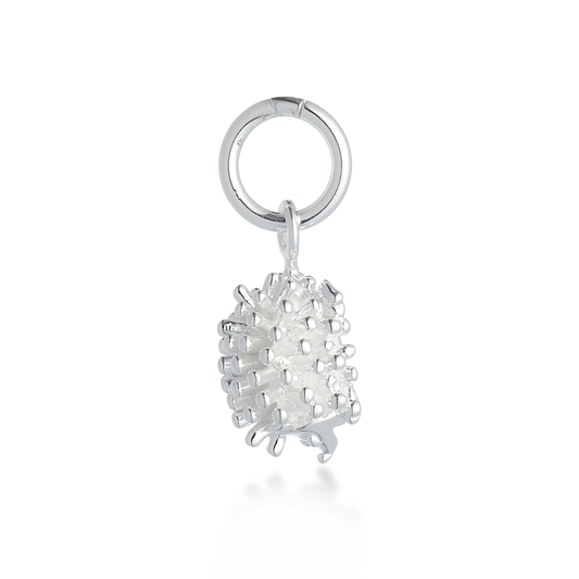 A silver hedgehog charm with detailed texture, displayed on a soft blue background by Scarlett Jewellery.