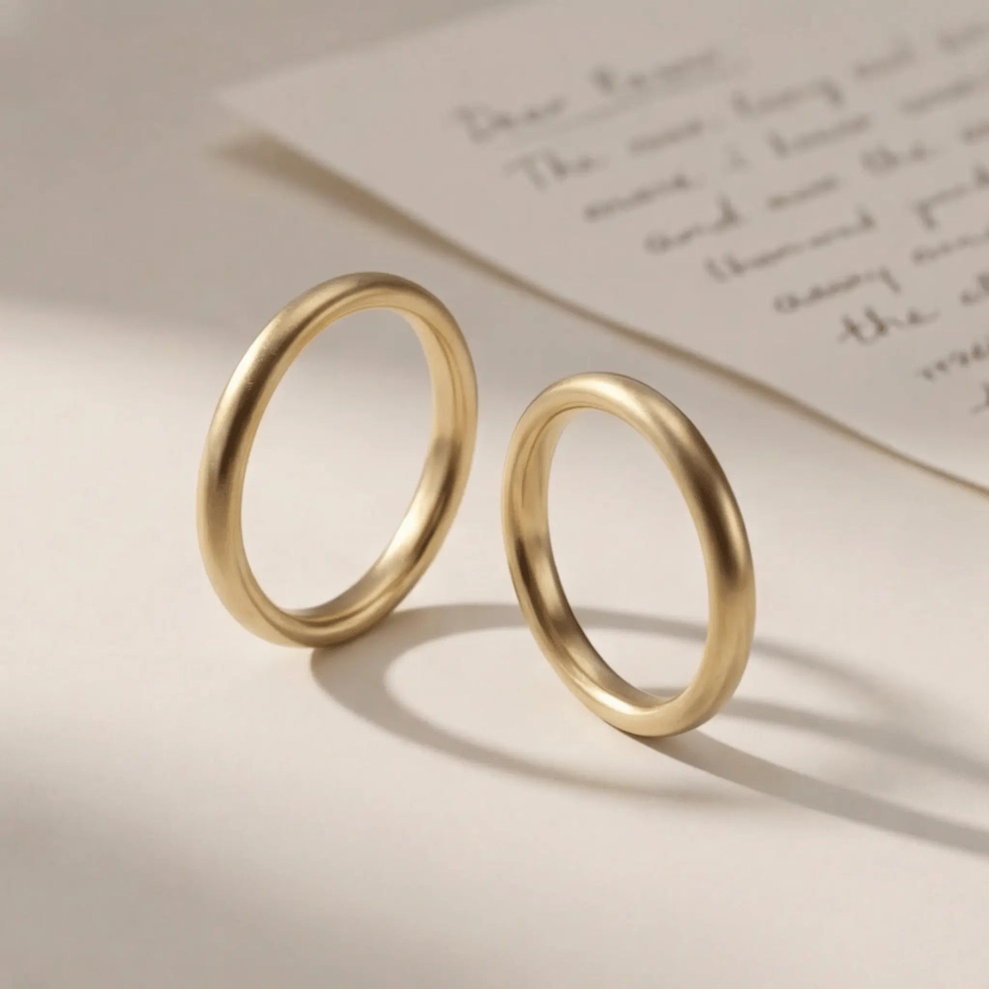 A slim gold wedding band set featuring a 2mm width in 9ct, 14ct, and 18ct gold by Majestic Jewellery.