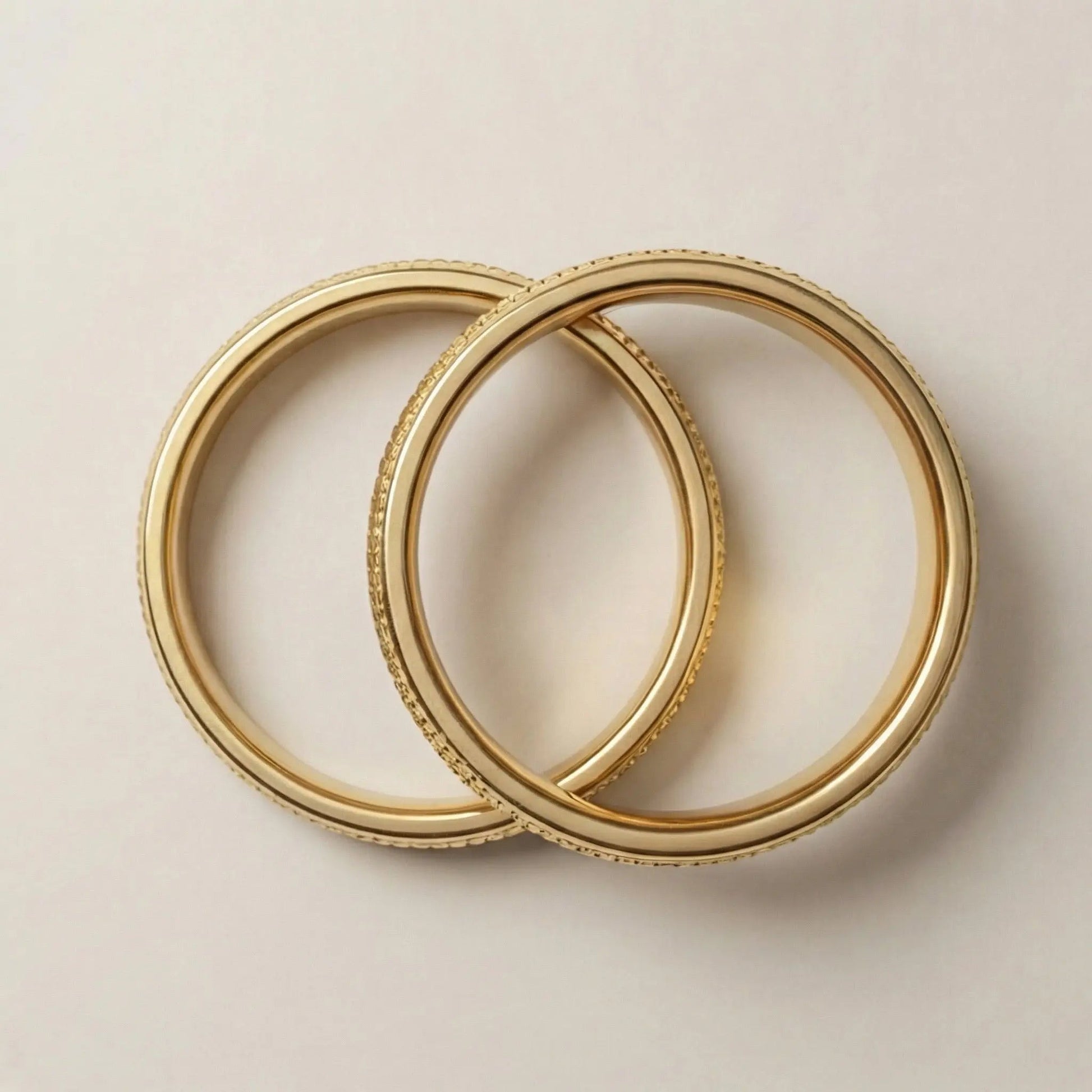 A 5mm gold wedding band with faceted milgrain detailing in 14ct gold, shown against a soft background by Majestic Jewellery.