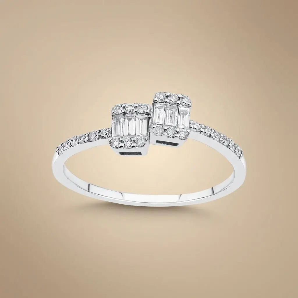 A 14ct white gold ring with two baguette diamonds and a 0.25ct center diamond, featuring an open design by Majestic Jewellery