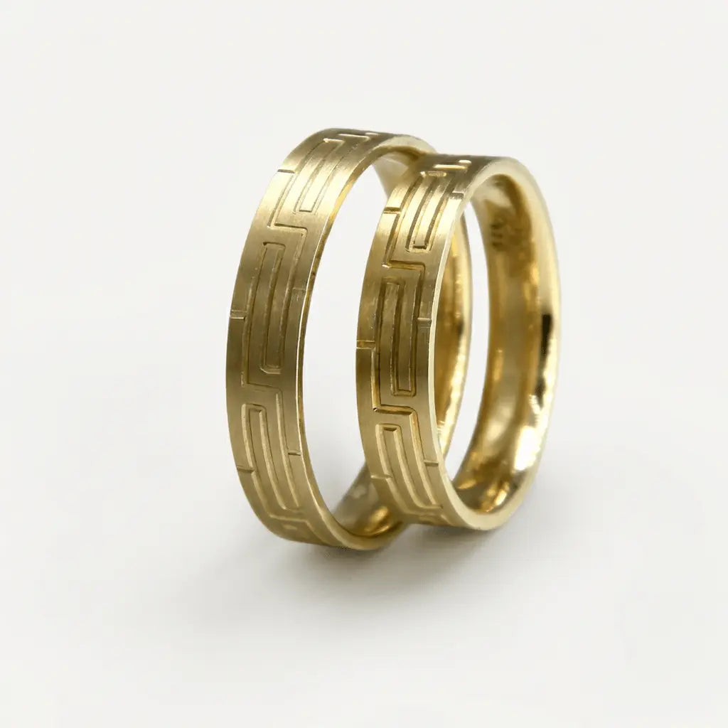 A 4mm gold wedding band with a geometric pattern in 9ct gold, shown against a neutral background by Majestic Jewellery.