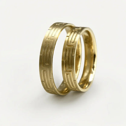 A 4mm gold wedding band with a geometric pattern in 9ct gold, shown against a neutral background by Majestic Jewellery.