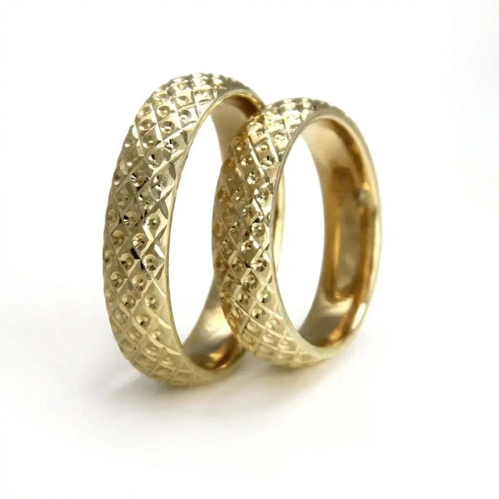 A 5mm gold wedding band with a faceted pattern in 9ct gold, shown against a neutral background by Majestic Jewellery.