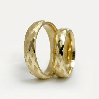 A 5mm gold wedding band with cross faceted design in 9ct gold, shown against a soft background by Majestic Jewellery.