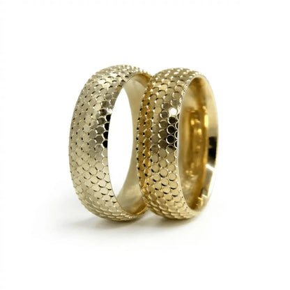 A 6mm gold wedding band with a disc texture in 9ct gold, shown against a black background by Majestic Jewellery.