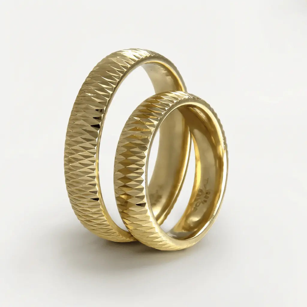 A faceted 5mm gold wedding band in 9ct gold worn on a finger by Majestic Jewellery.