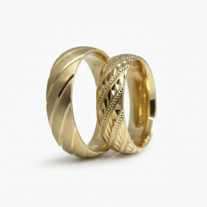 A 6mm gold wedding band with a diagonal lattice faceted design in 14ct gold worn on a finger by Majestic Jewellery.