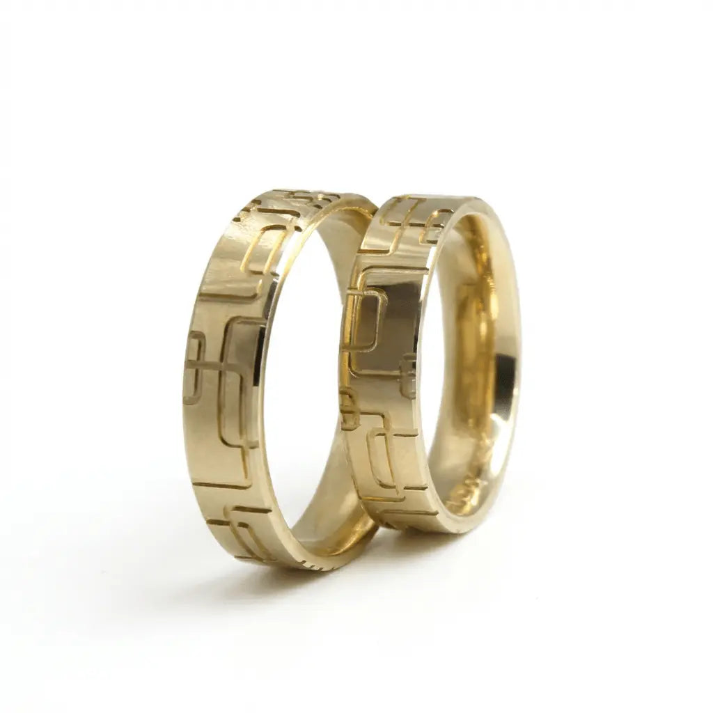 A 5mm gold wedding band with a geometric block pattern in 9ct gold, shown as a close-up of the textured surface by Majestic J