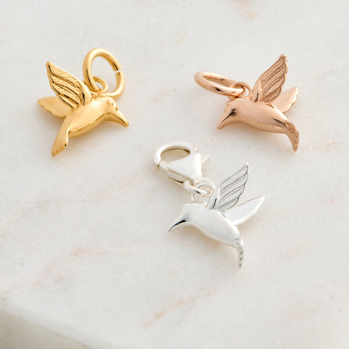 Silver hummingbird charm with delicate wings, displayed on a soft white background, part of the Scarlett Jewellery collection