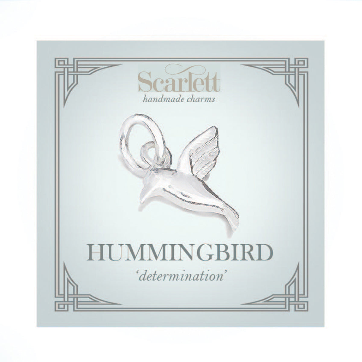 Silver hummingbird charm with delicate wings, styled on a jewelry display by Scarlett Jewellery.