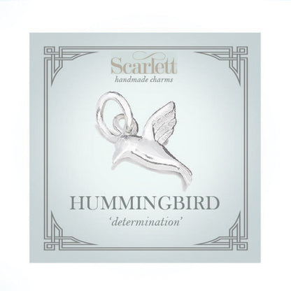 Silver hummingbird charm with delicate wings, styled on a jewelry display by Scarlett Jewellery.