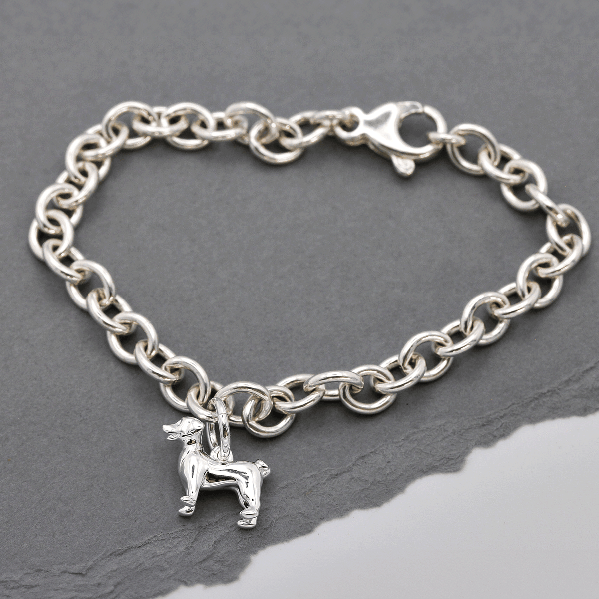 Silver Jack Russell Terrier dog charm by Scarlett Jewellery displayed on a soft fabric background.