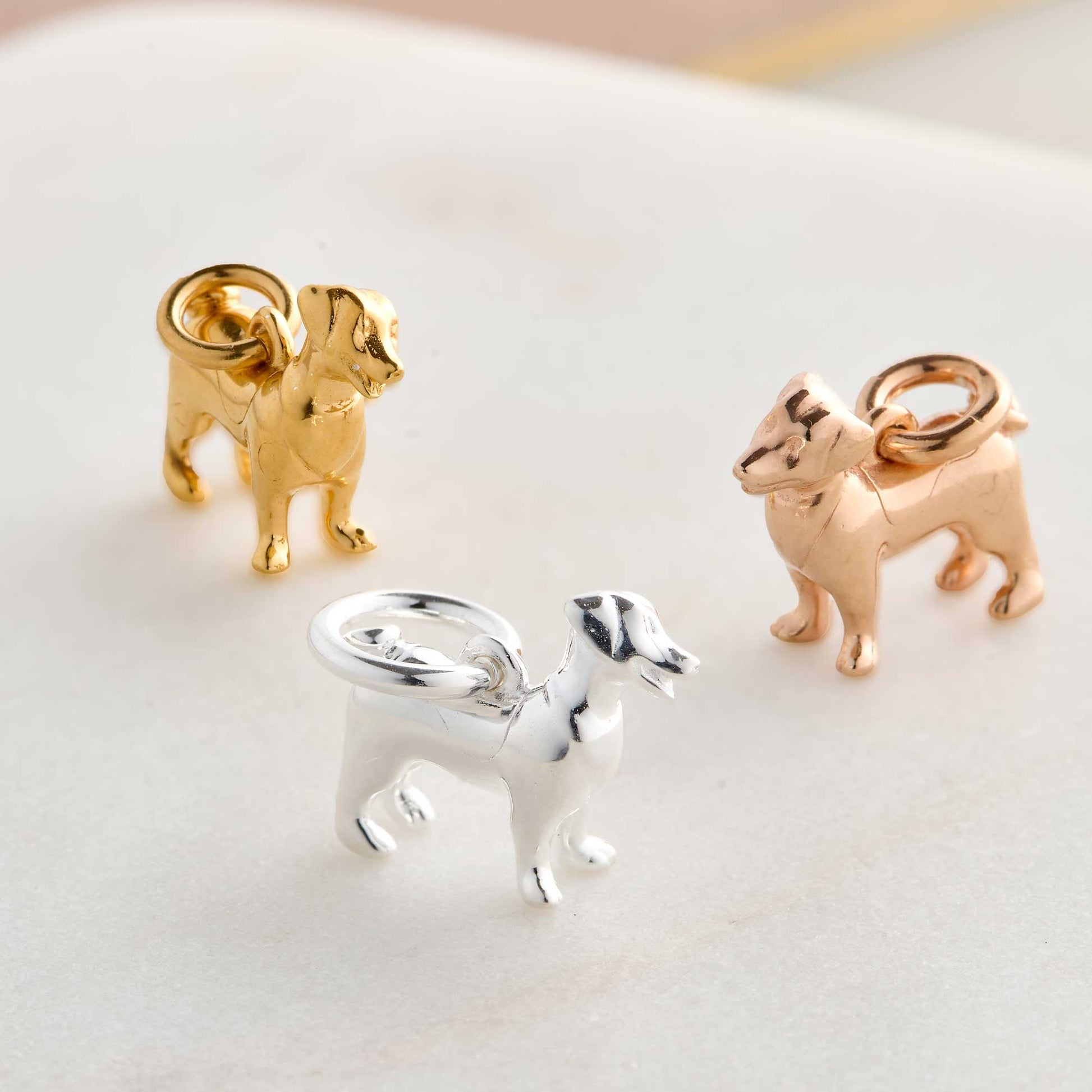 Silver Jack Russell Terrier dog charm by Scarlett Jewellery displayed on a soft fabric background.