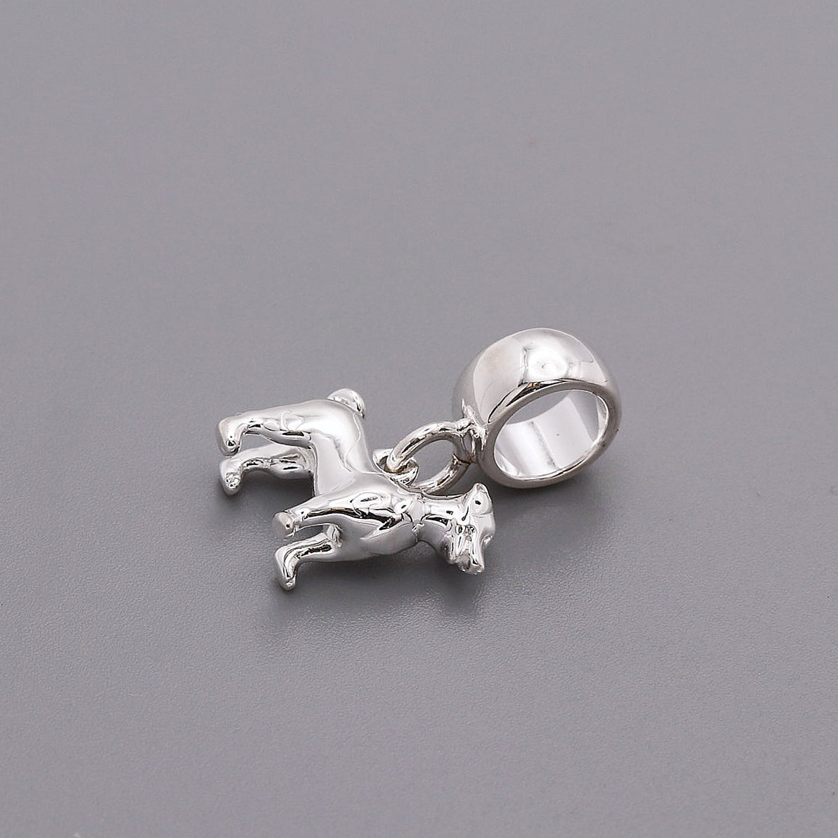 Silver Jack Russell Terrier dog charm by Scarlett Jewellery displayed on a soft fabric background.