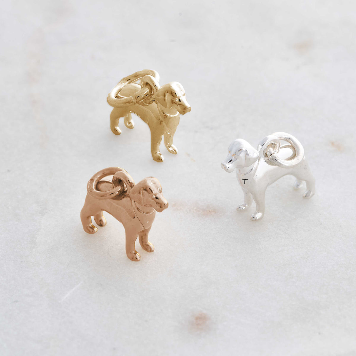 A silver Labrador dog charm with detailed texture, shown against a soft background, by Scarlett Jewellery.