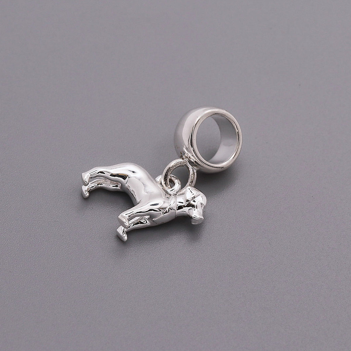 A silver Labrador dog charm shaped like a paw print, displayed on a white background with a soft texture, by Scarlett Jewelle