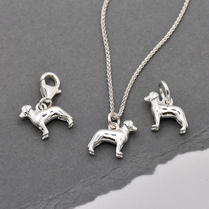 A silver Labrador dog charm shaped like a paw print, displayed on a white background with a soft texture, by Scarlett Jewelle