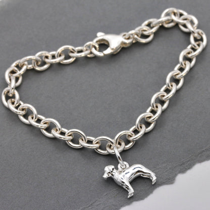 A silver Labrador dog charm with detailed texture, displayed on a soft blue background by Scarlett Jewellery.
