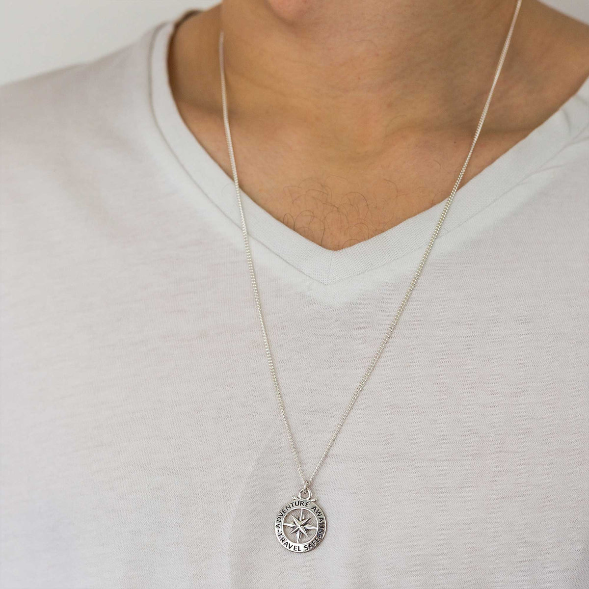 A large silver necklace featuring a detailed compass outline and the word "St Christopher" by Scarlett Jewellery.