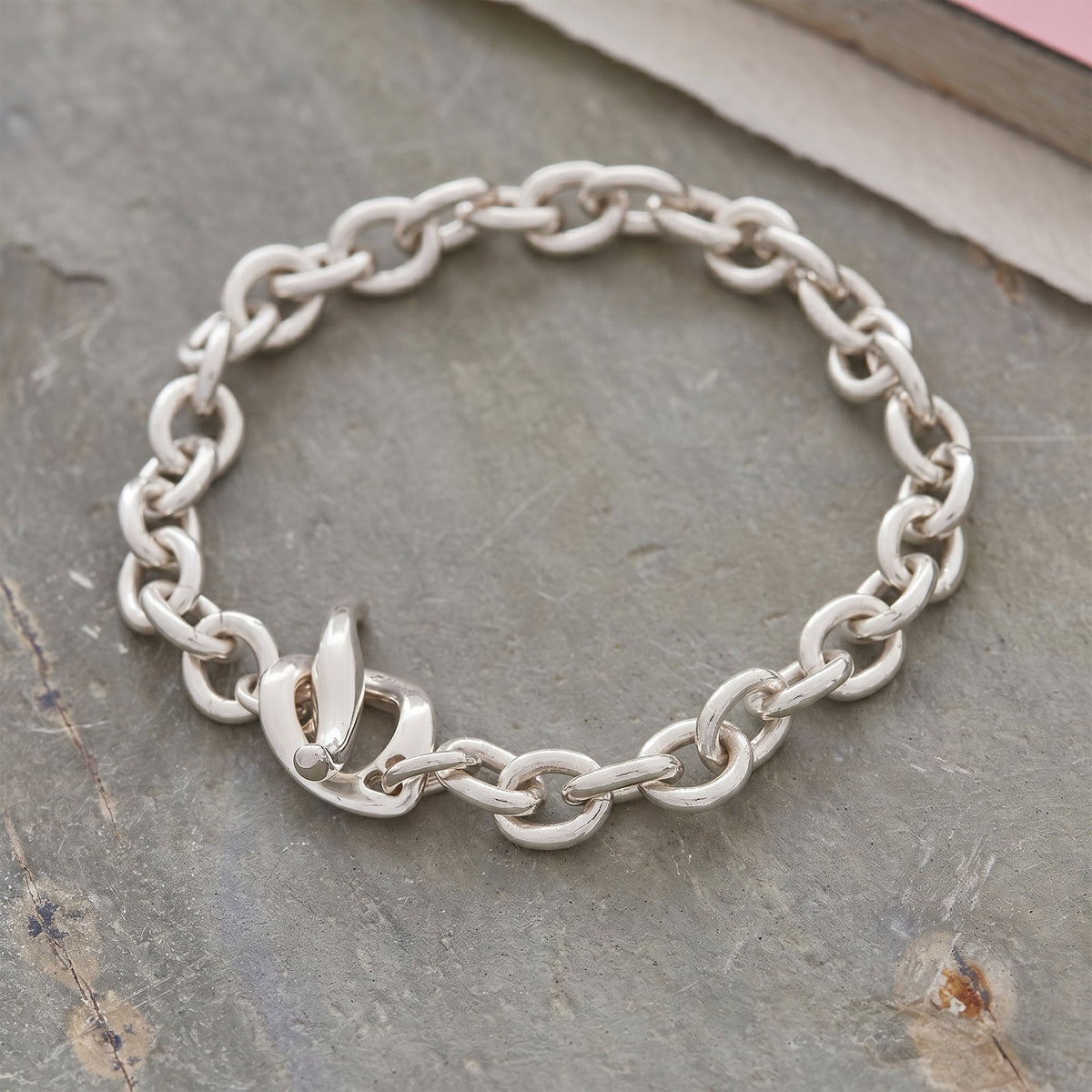 Silver charm bracelet with heart and star charms, featuring a sleek design by Scarlett Jewellery.