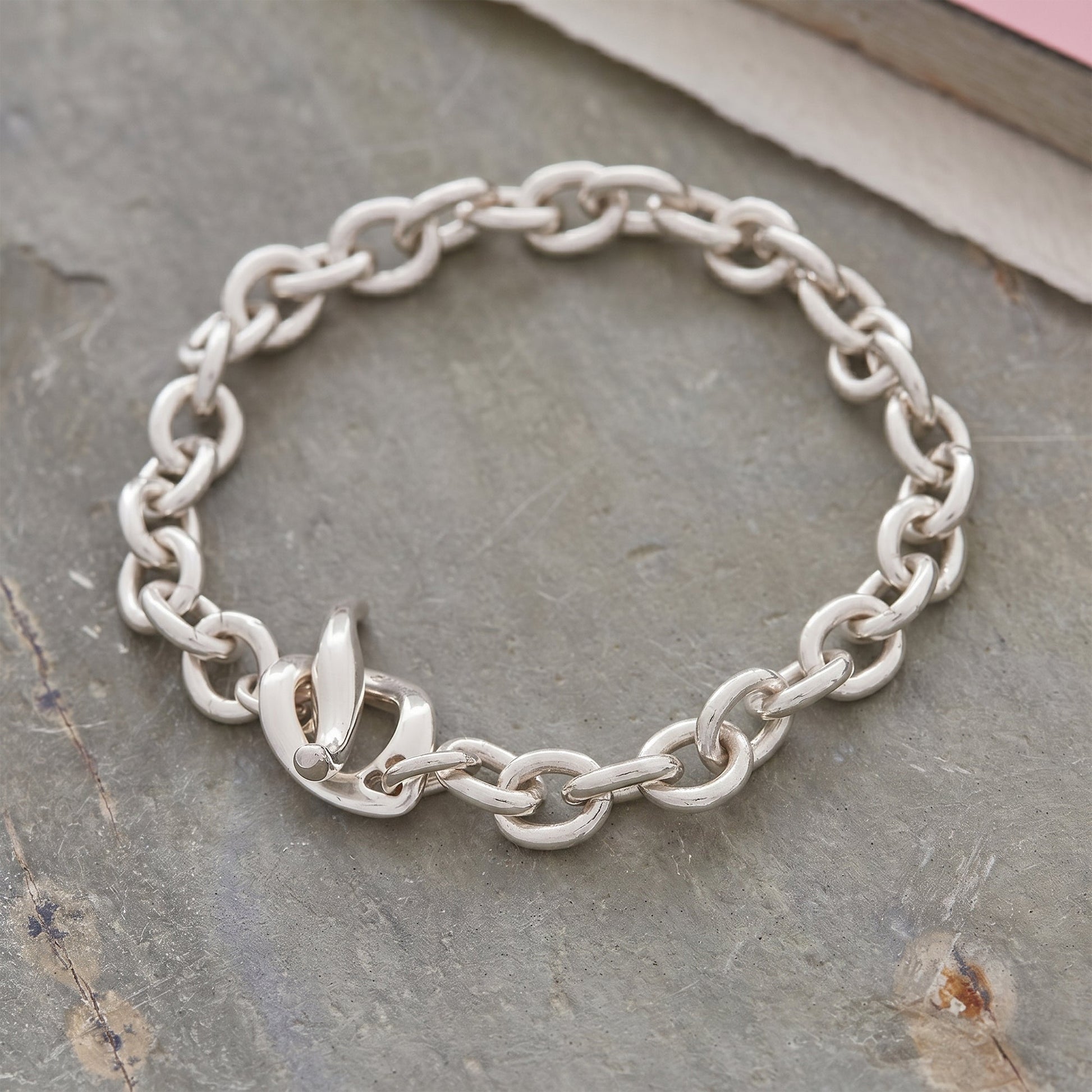 Silver charm bracelet with heart and star charms, featuring a sleek design by Scarlett Jewellery.