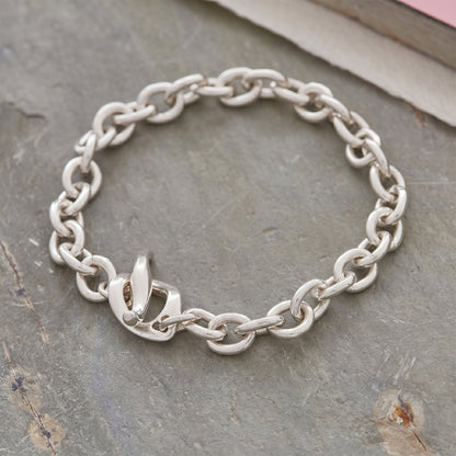 Silver charm bracelet with heart and star charms, featuring a sleek design by Scarlett Jewellery.