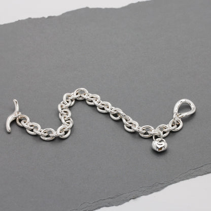 Silver heart charm bracelet with delicate chain and engraved details by Scarlett Jewellery.