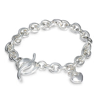 A silver heart charm bracelet with a detailed textured finish, featuring a central heart pendant, by Scarlett Jewellery.