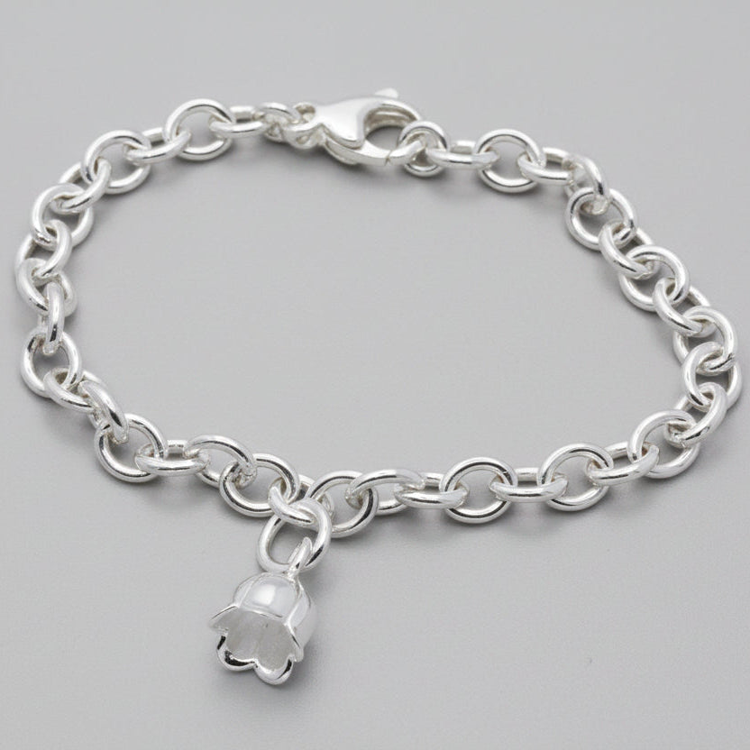A silver lily of the valley flower charm with delicate detailing, displayed on a soft white background by Scarlett Jewellery.