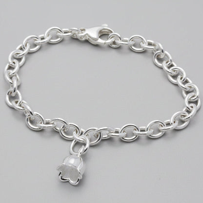 A silver lily of the valley flower charm with delicate detailing, displayed on a soft white background by Scarlett Jewellery.